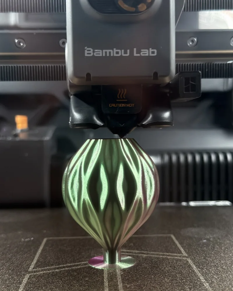 Печатающая головка Bambu Lab над игрушкой: сопло у самой макушки, виден ромбовидный рельеф
